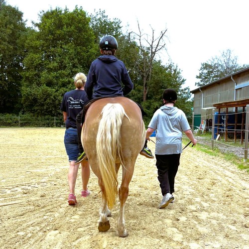 Kind auf Pferd wird geführt